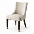 Silla de lino beige con patas de madera y detalles de latón